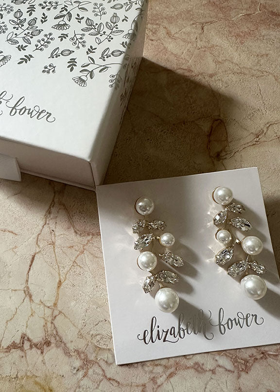 gold and crystal earrings on marble