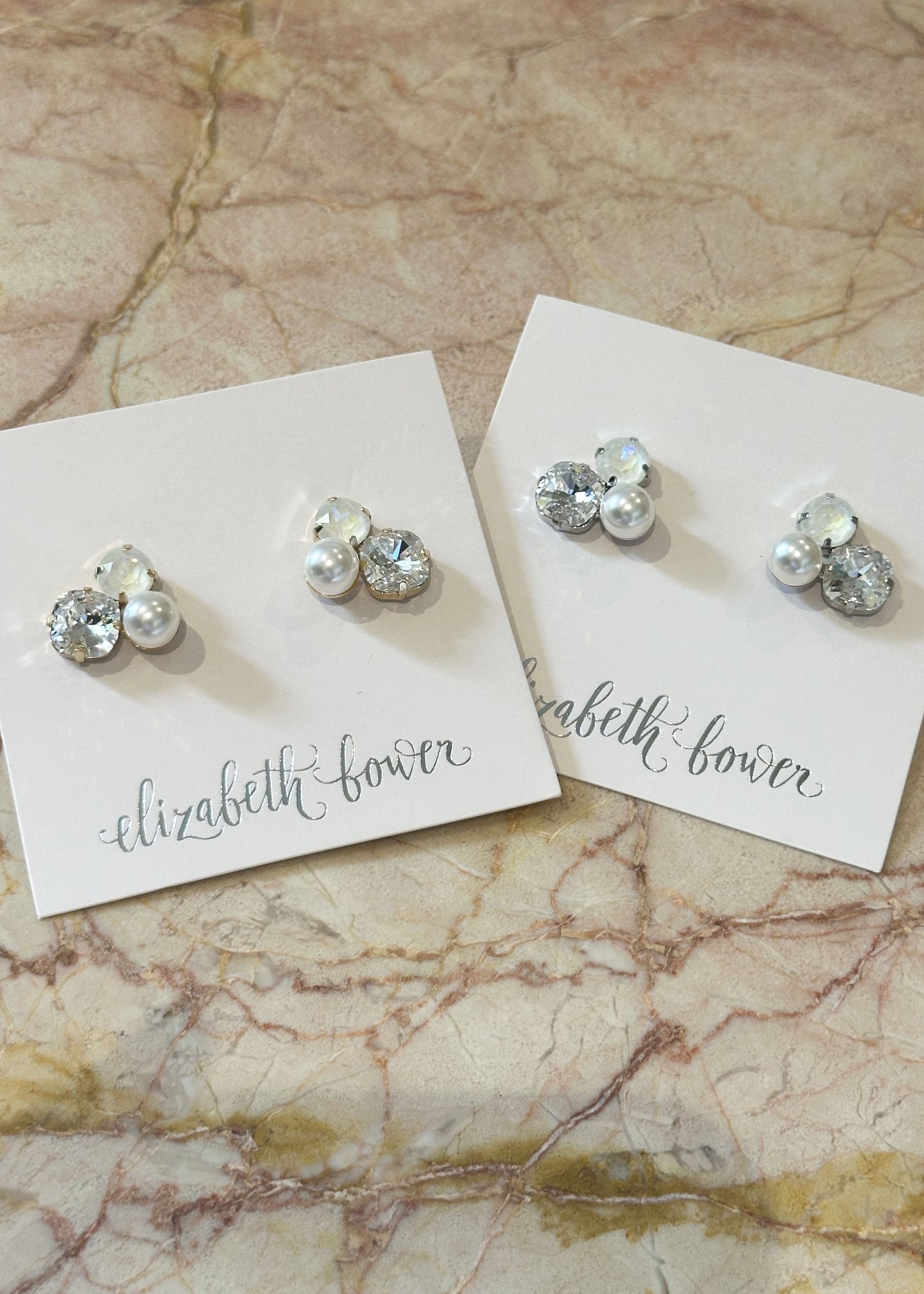Two pairs of Stud earring made from trio of Swarovski crystals and pearls on marble