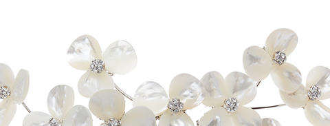 Pearl flower hair accessory with small crystals on a white background