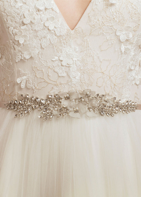 Close-up of a lace wedding dress with a decorative belt