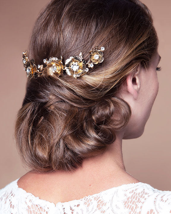 Woman with elegant hair styled with a decorative headpiece against a neutral background