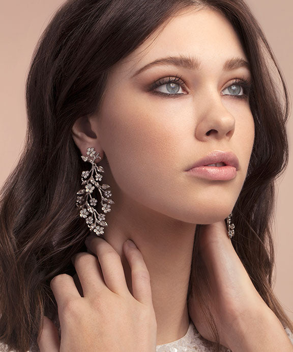 Woman wearing elegant earrings with a soft background