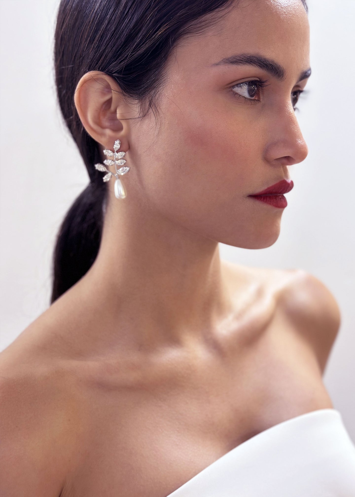 Floral crystal stud earring with pearl accent on model with red lipstick