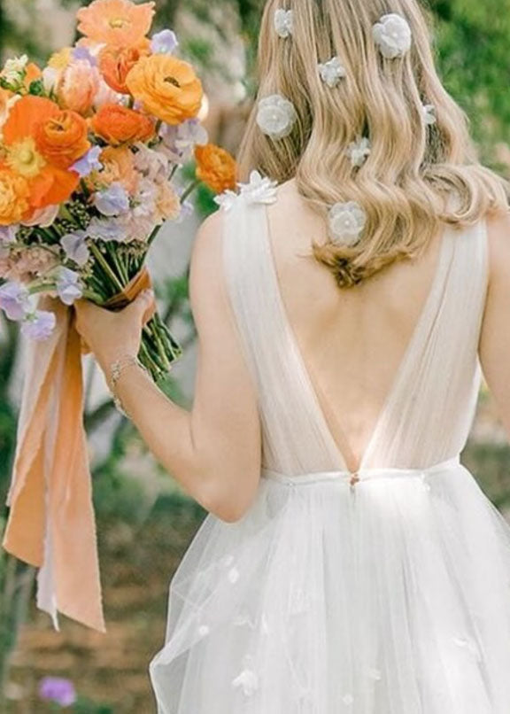 Floral silk hairpins on bride in dress with floral bouquet