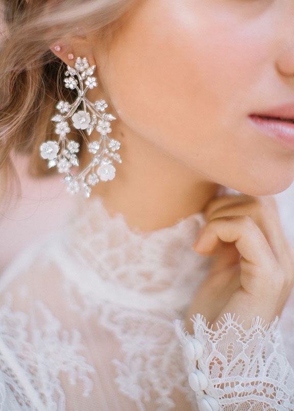 floral hoop earring on bride in lace dress (close up view)