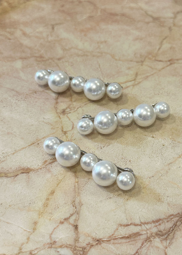 Pearl hairpin with five alternating pearls in a row on marble background