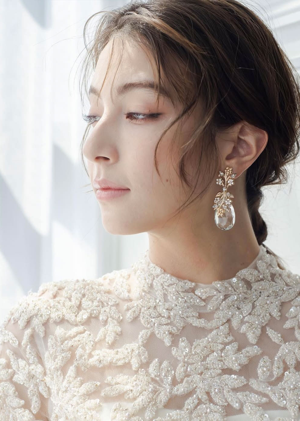 A lady in a lace dress wearing a floral crystal teardrop earring