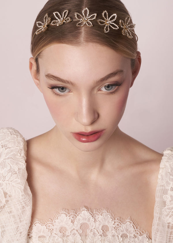 Scattered floral gold crystal hairpiece laid flat on model in lace wedding dress (front view)