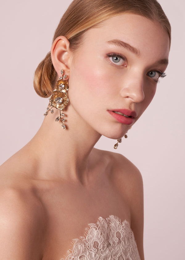 Double gold floral and crystal statement earring on model