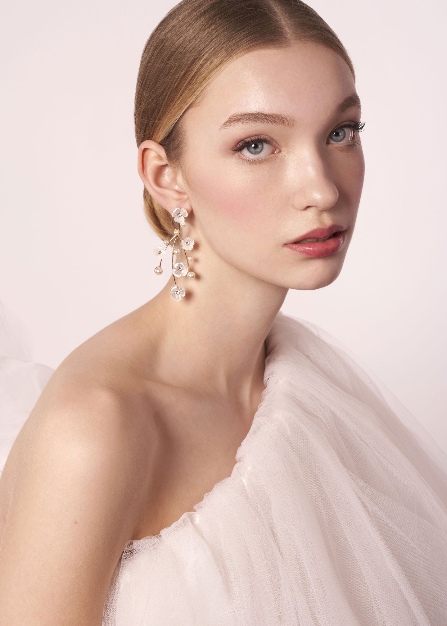 Mother of pearl gold floral chandelier earring on model in tulle wedding dress (portrait view)