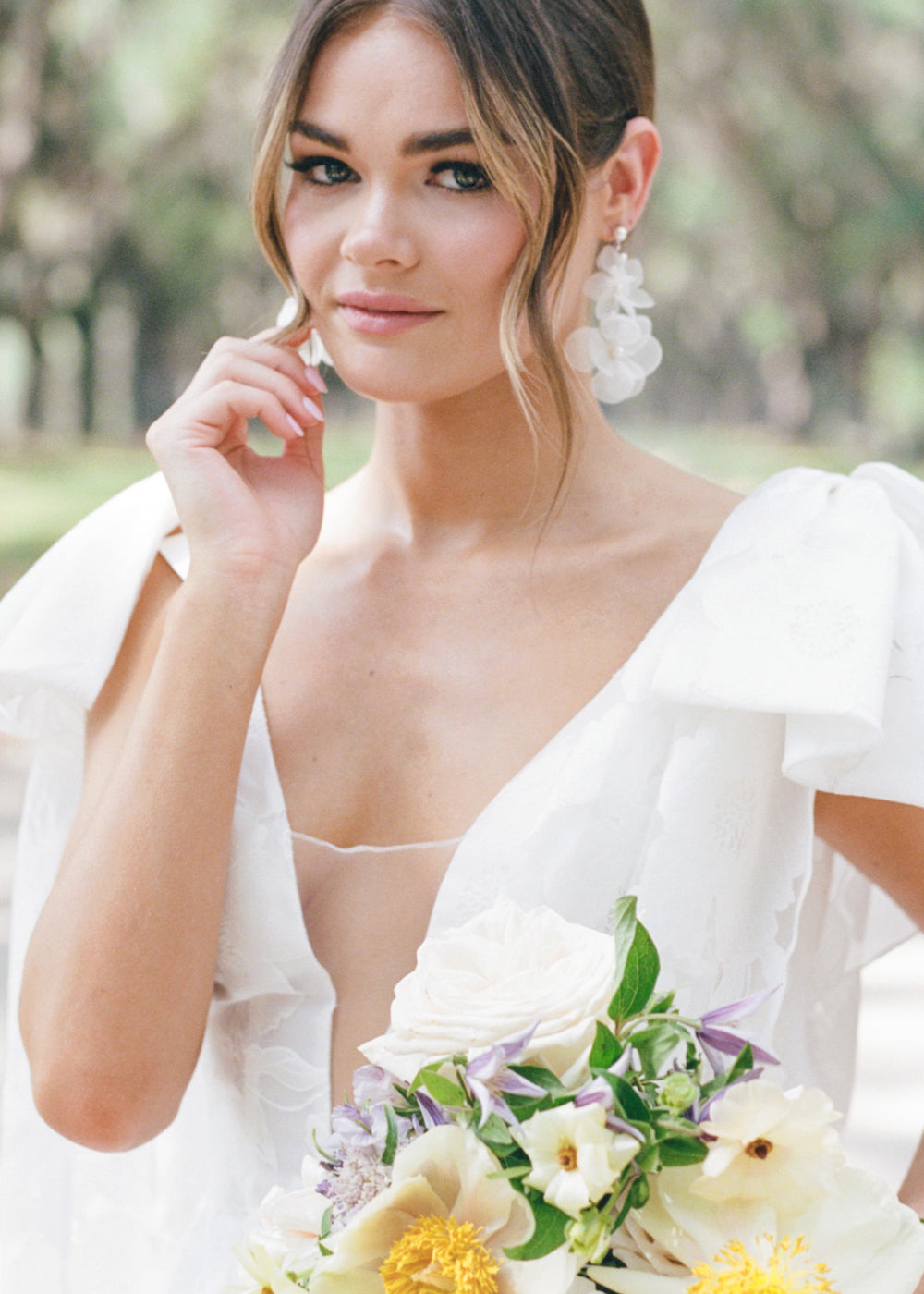 Silk floral drop earring in ivory and silver on side in v neck dress