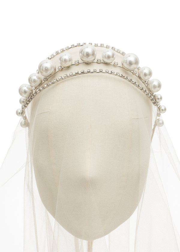 Pearl and Crystal bridal hairpiece on headstand with tulle on white background.