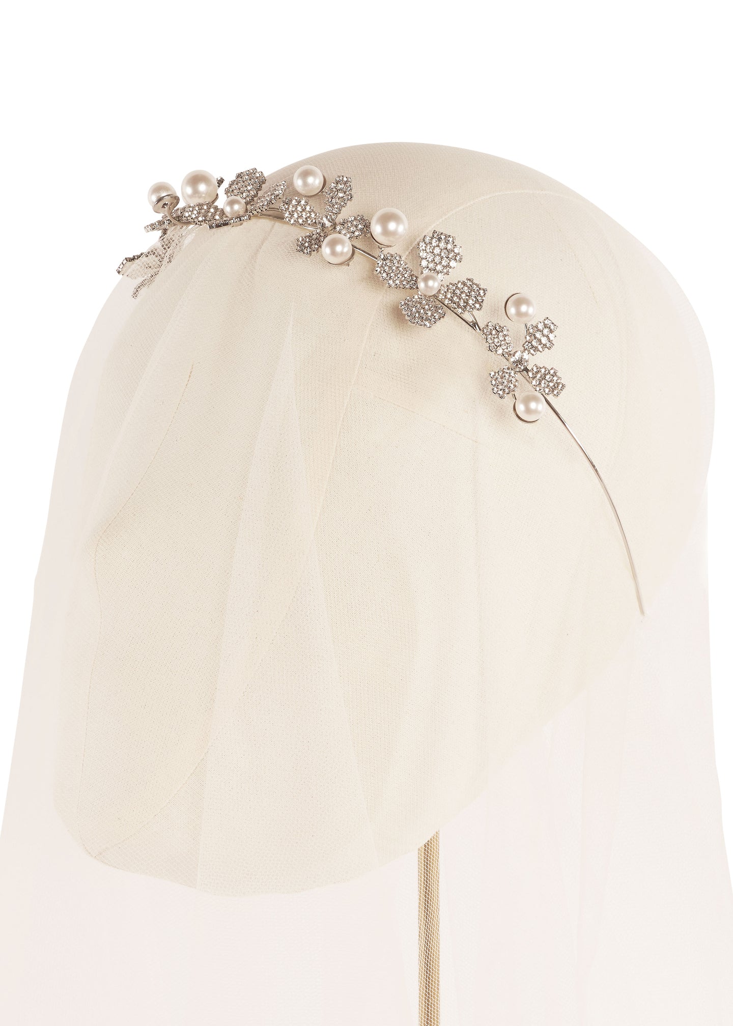 Pearl and crystal floral bridal hairpiece on headstand covered in tulle (white background)