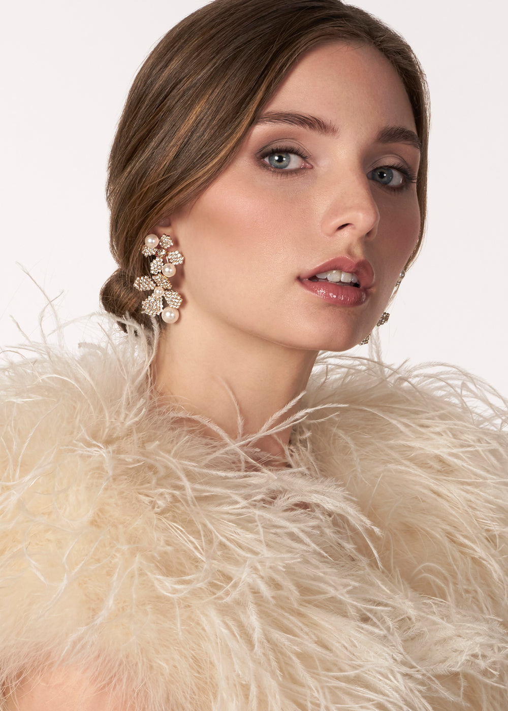 Gold crystal double flower earring with pearl accents on model side view 2