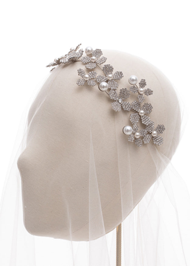 statement floral bridal hairpiece on headstand side view with tulle