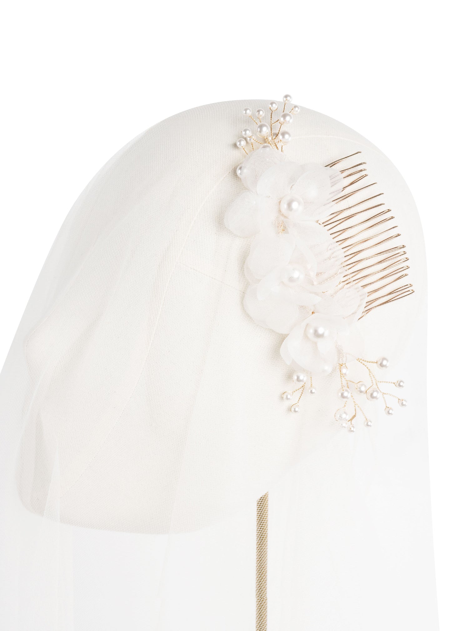 a golkd and silk floral hair comb acented with pearls postition on headstand with tulle.