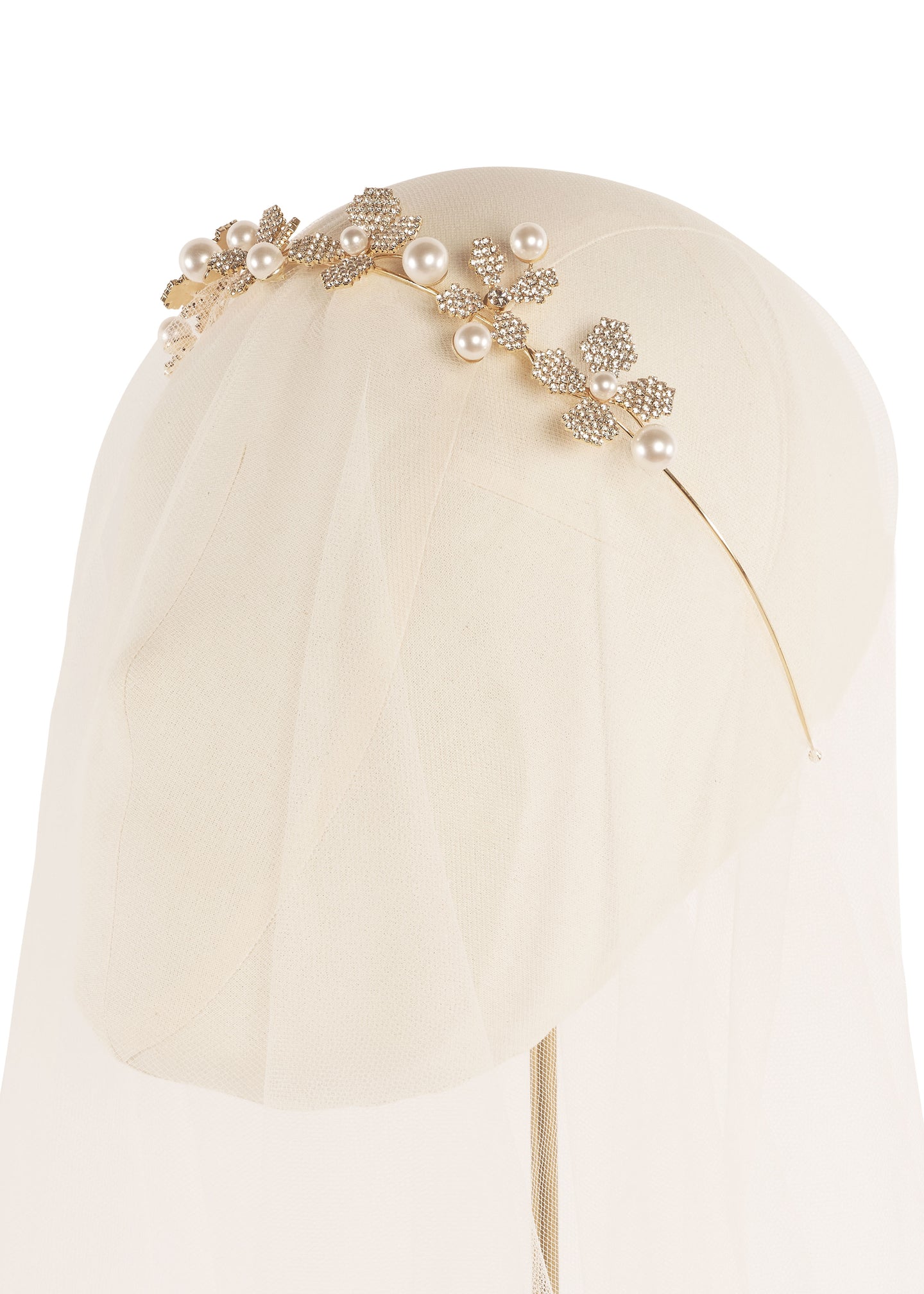 Pearl and crystal gold floral bridal hairpiece on headstand with tulle veil