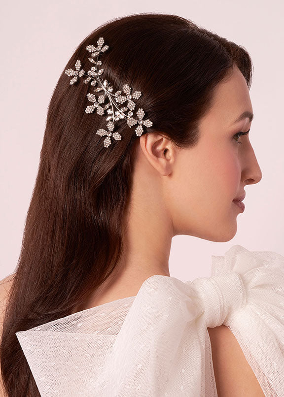 Woman wearing a decorative hairpiece with a plain background