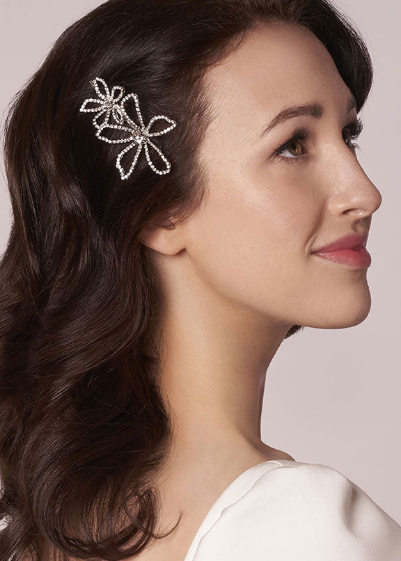 Woman wearing a decorative hairpin with a plain background