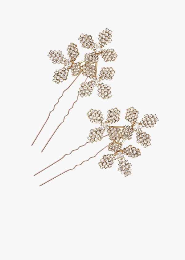 A set of two Floral golden bridal hair pins set against a neutral backing