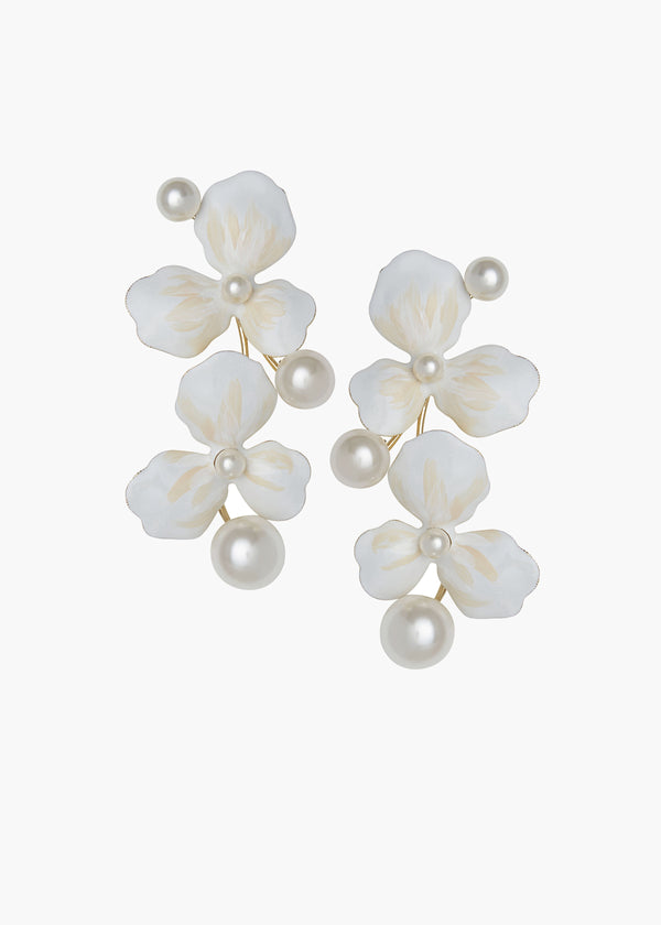 Pair of white floral earrings with pearl-like beads on a white background