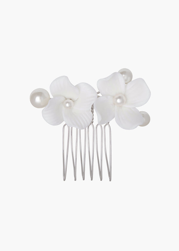 Hair comb with white floral attachments and pearls on a white background