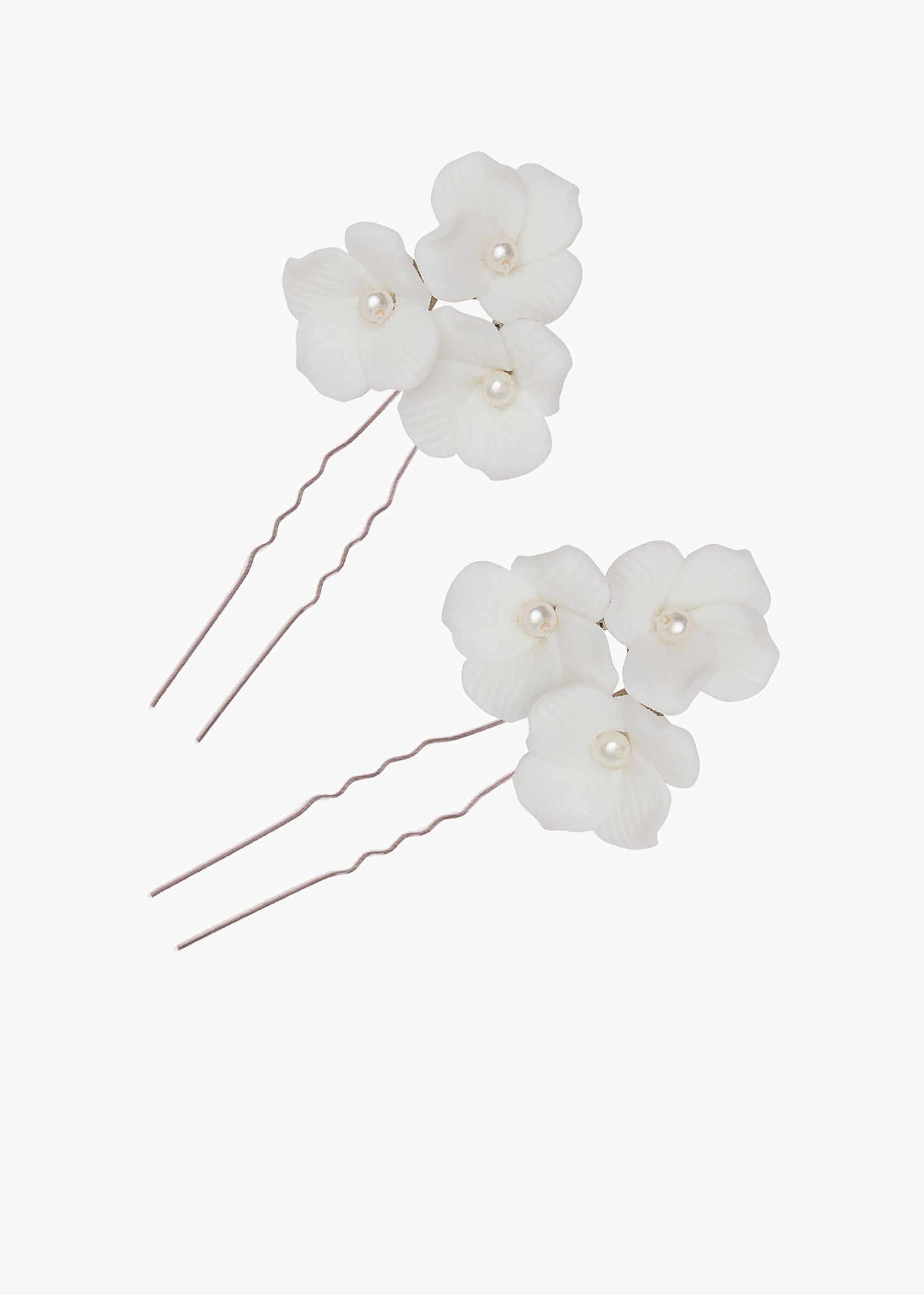 Set of three white floral hairpins with pearls on a white background