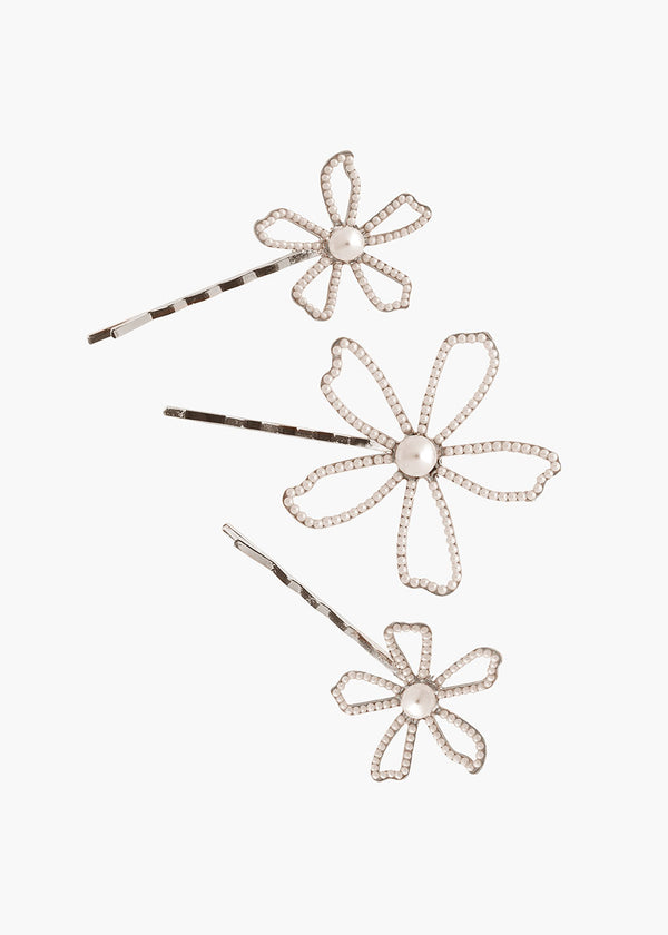 Three decorative hair pins with floral designs on a white background