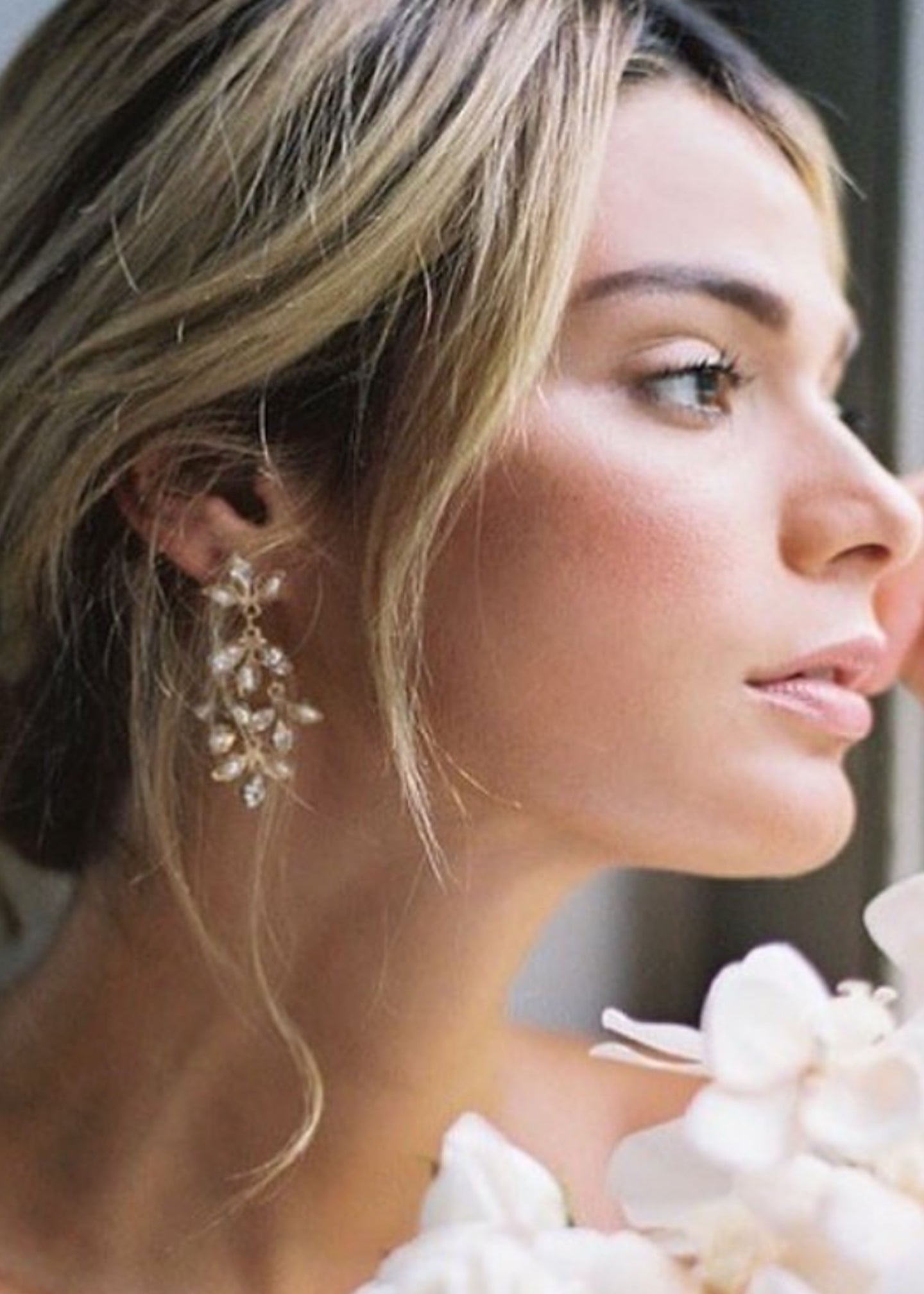Close-up of a woman wearing elegant earrings with a blurred background