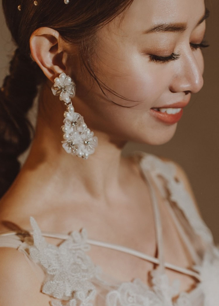 Close-up of a woman wearing elegant earrings with a soft focus background