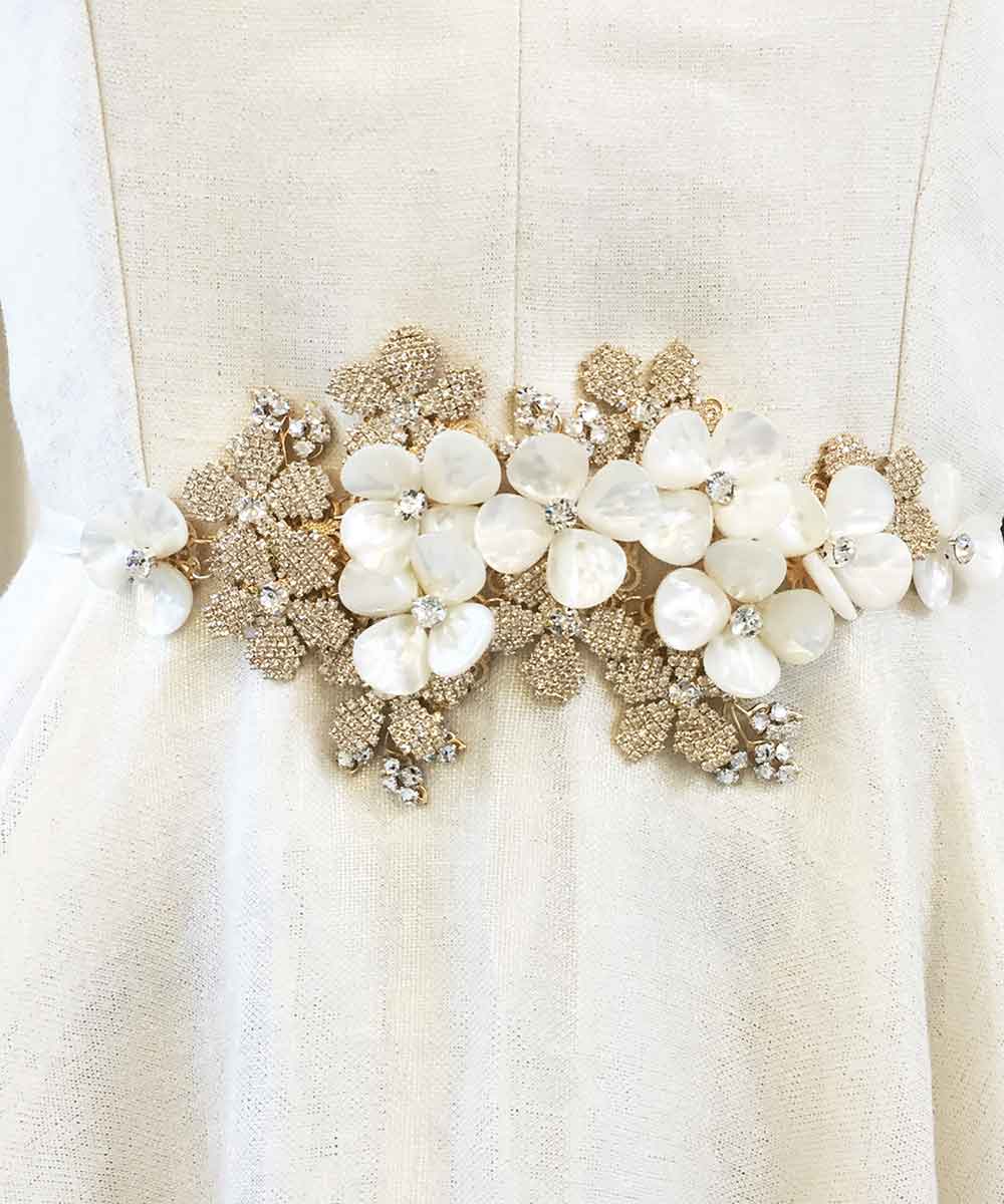 A floral dress belt with mother of pearl pearls and crystals on a white dress