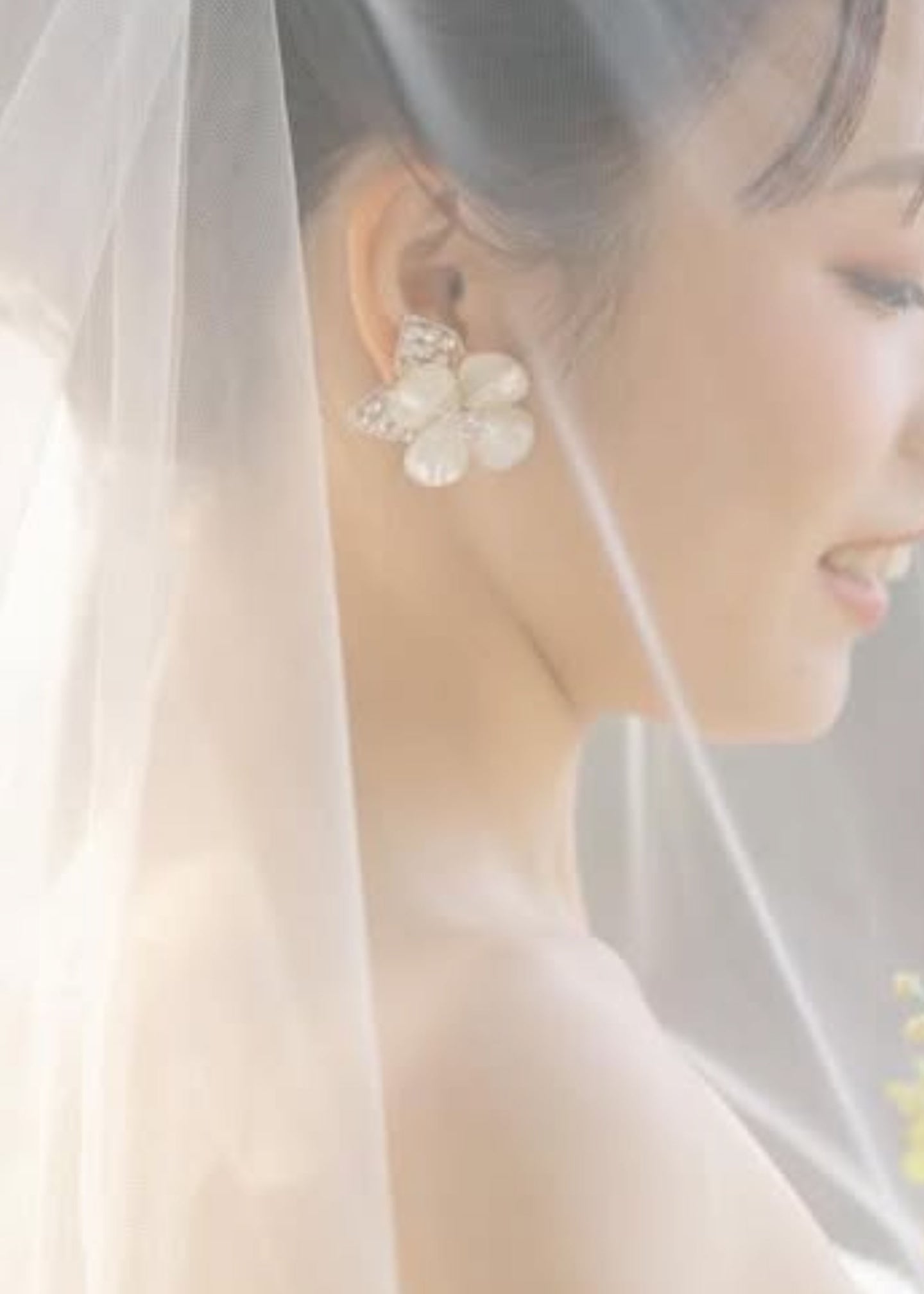 Close-up of a person wearing a floral earring with a soft focus background
