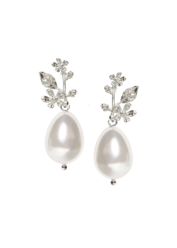 A pair of pearl earrings finished with a silver leaf top on a white background
