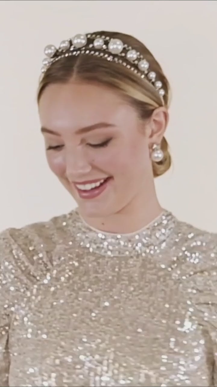 A lady dancing wearing a silver sequin dress and pearl headband