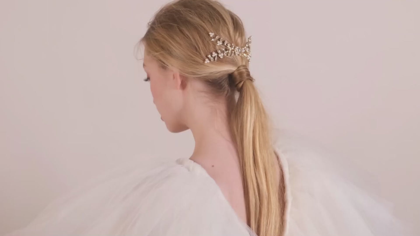 Pearl and crystal statement wedding hair comb on lady in tulle dress on a beige background
