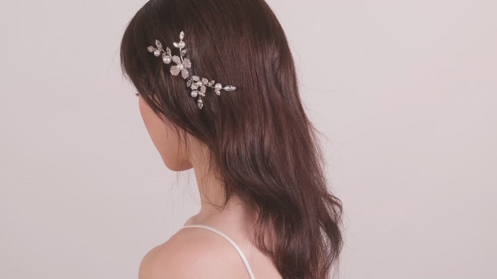 a lady wearing a floral crystal and pearl hair comb against a blush background