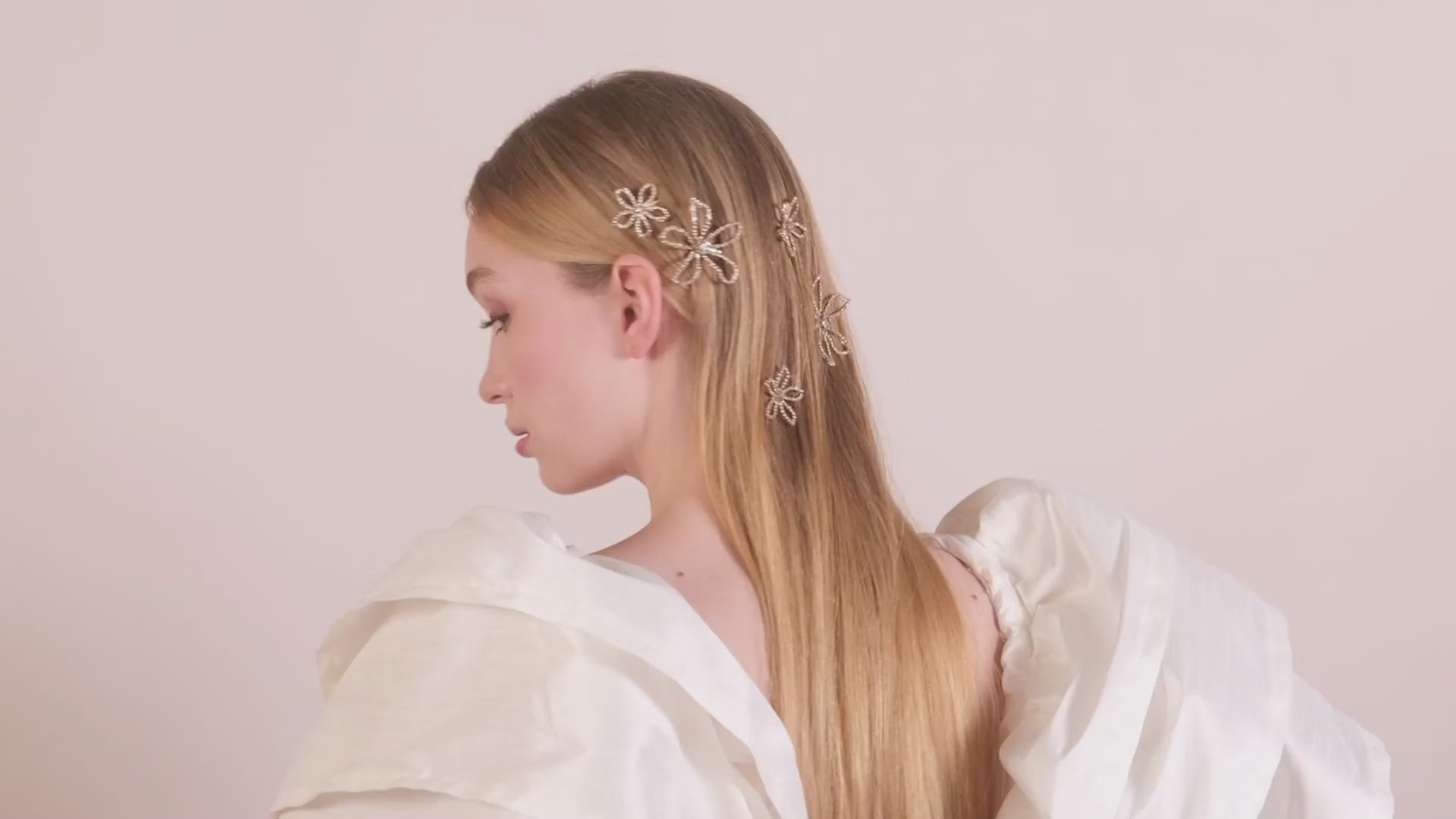 A lady turning her head wearing scattered crystal floral hairpins 