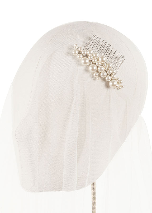 a Pearl hair comb on a white hairpiece with a white background