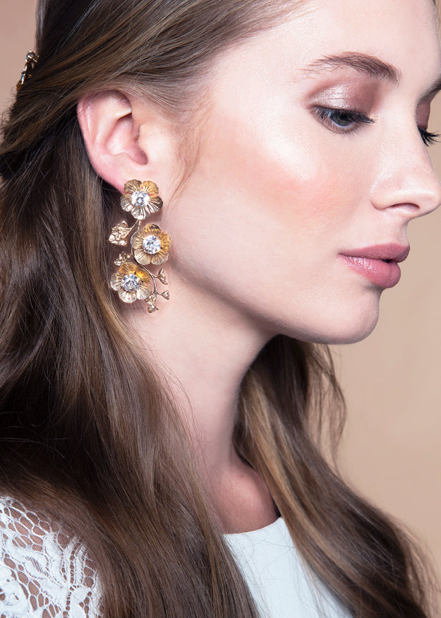 Floral golden drop bridal earring with crystal  centers on model 