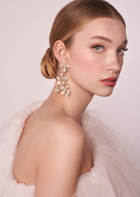 Crystal floral gold chandelier earring on model in tulle dress (side view)