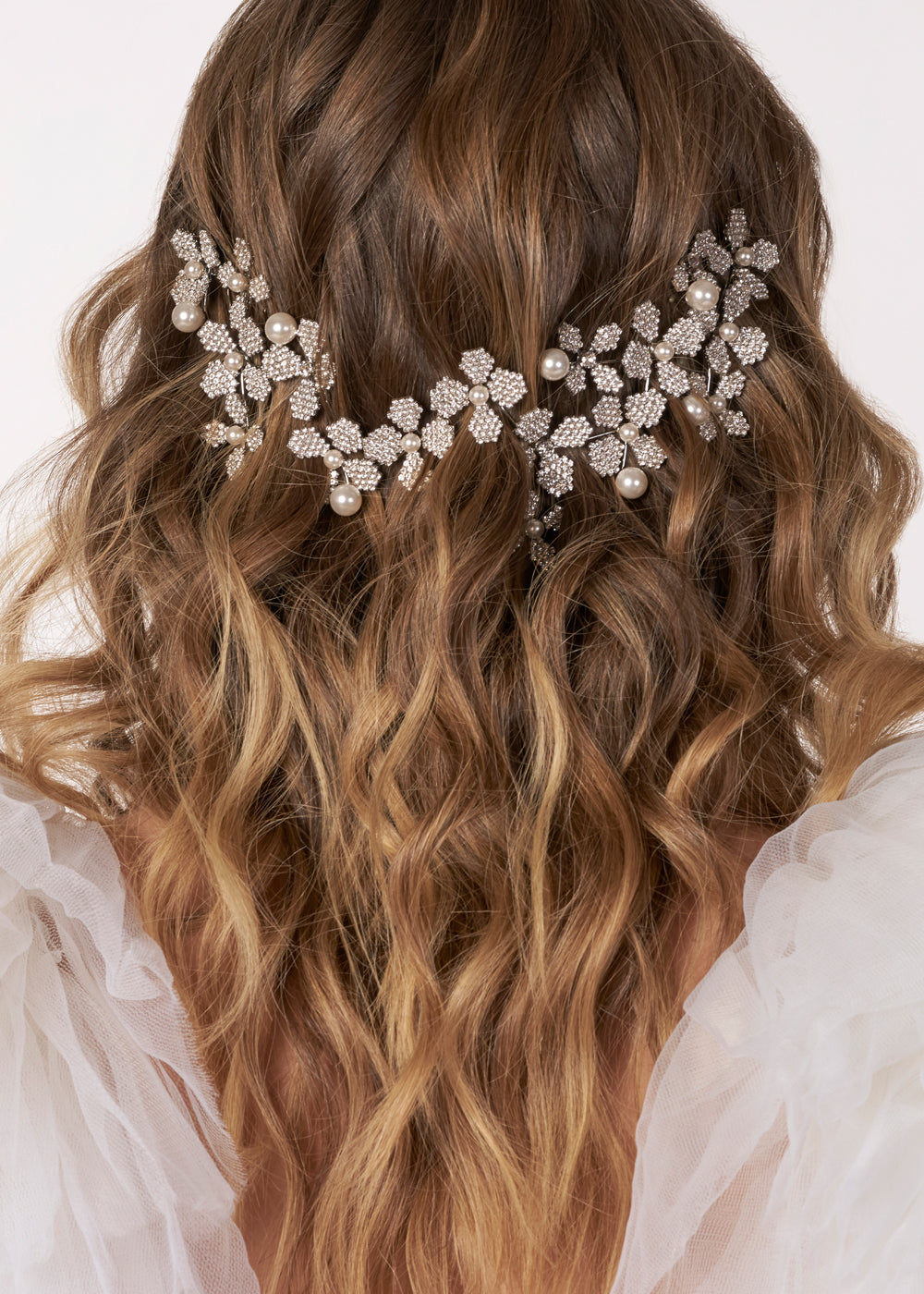 Floral crystal and pearl hairpiece on model with loosly curly hair (back view) 