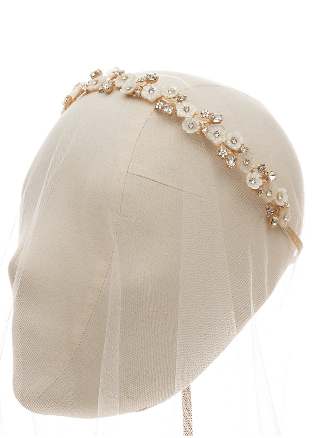 Gold floral wedding hairpiece on head stand with tulle