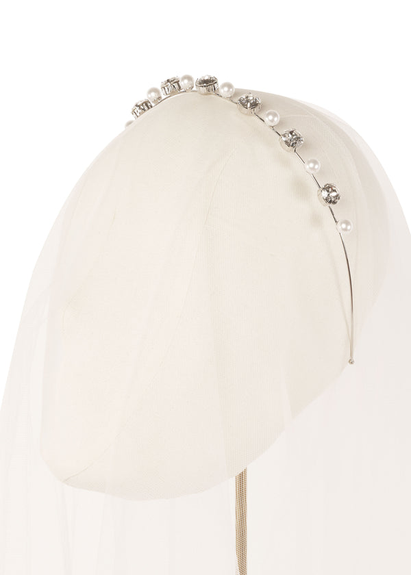 A pearl and crystal mini headband on a head stand