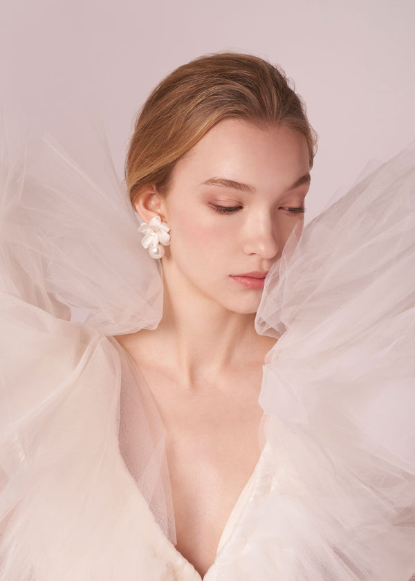 Silk and pearl gold floral bridal stud earring on model in tulle dress (front view)