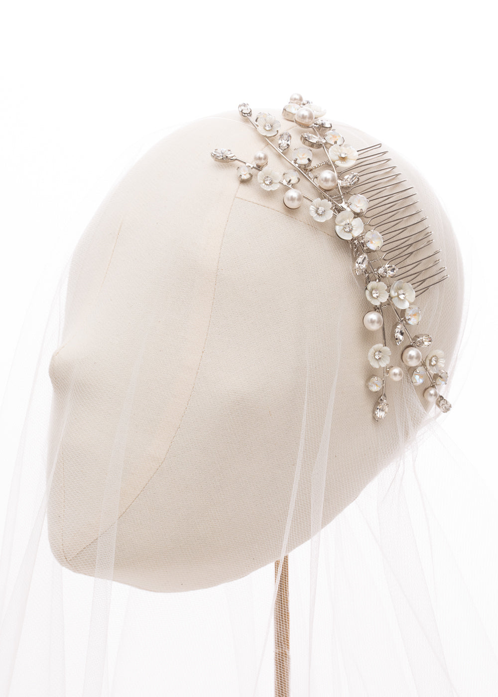 Floral bridal hairpiece on headstand with tulle veil 